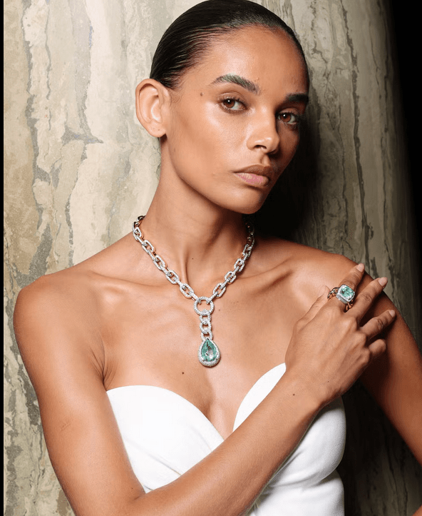Model wearing a diamond chain necklace with aquamarine pendant and matching ring
